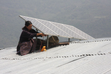 A woman installing solar panels on the roof in Bhutan