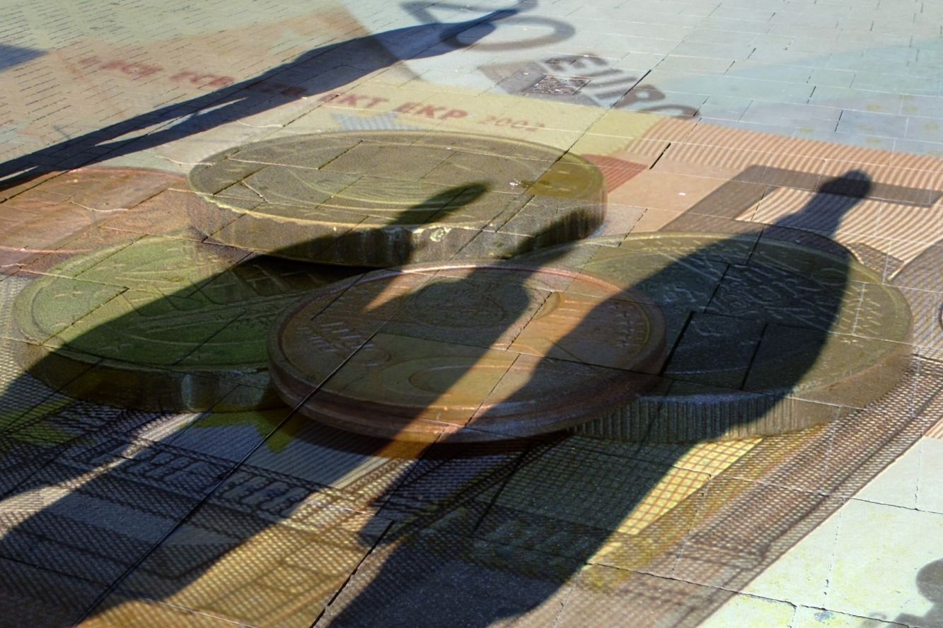 Human shadows being cast on euro notes