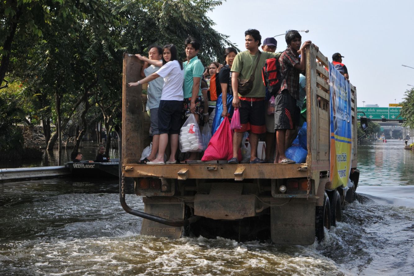 People standing on the back of a truck going through water
